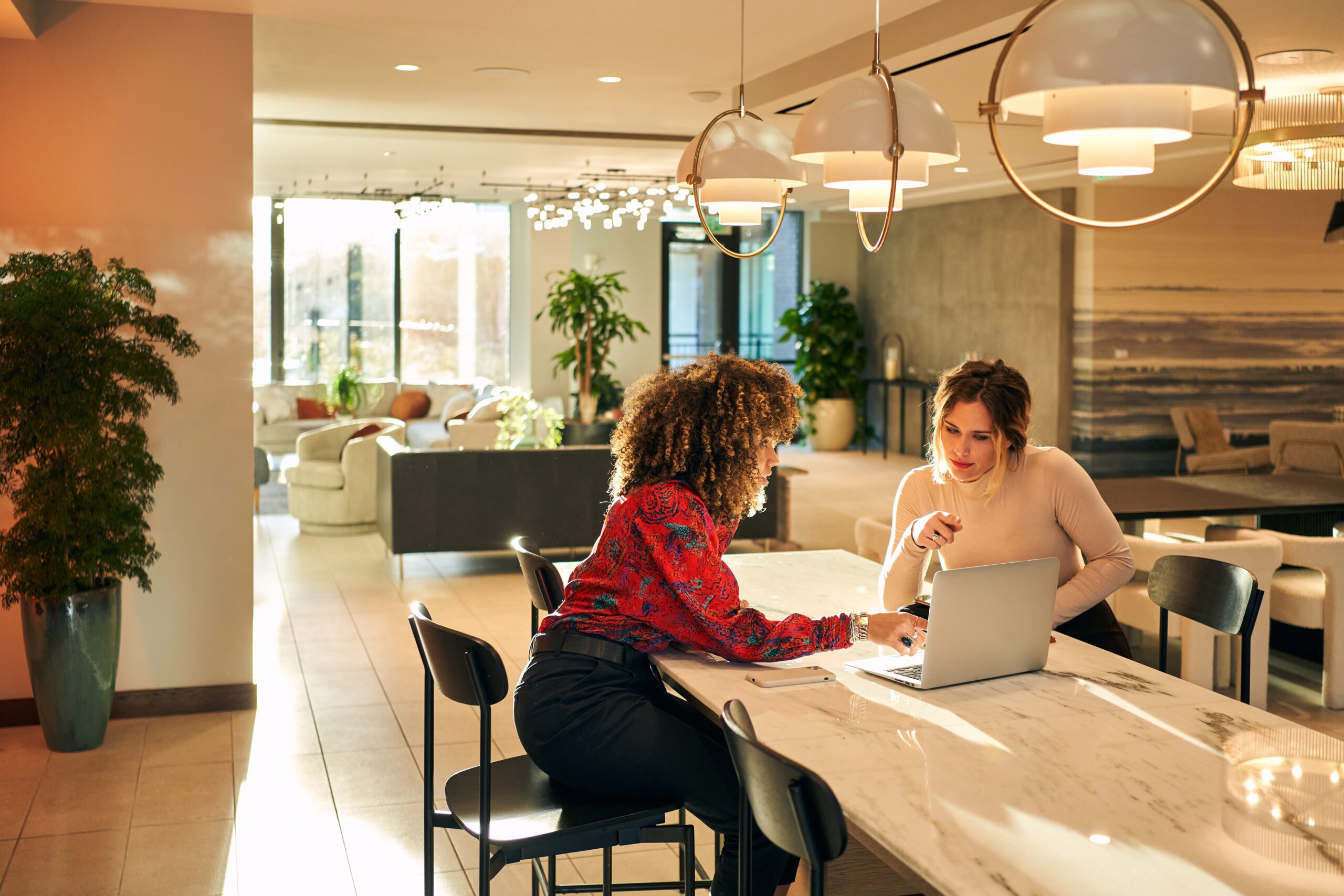 Leaders discussing feedback and workplace communication while reviewing work on a laptop